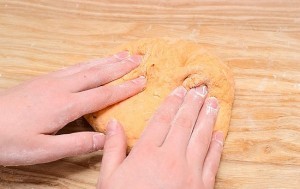 nan khoi bot thanh hinh tru dai, roi dat khoi bot vao to giay bac. roi cuon tron khoi bot xoan chat hai dau.